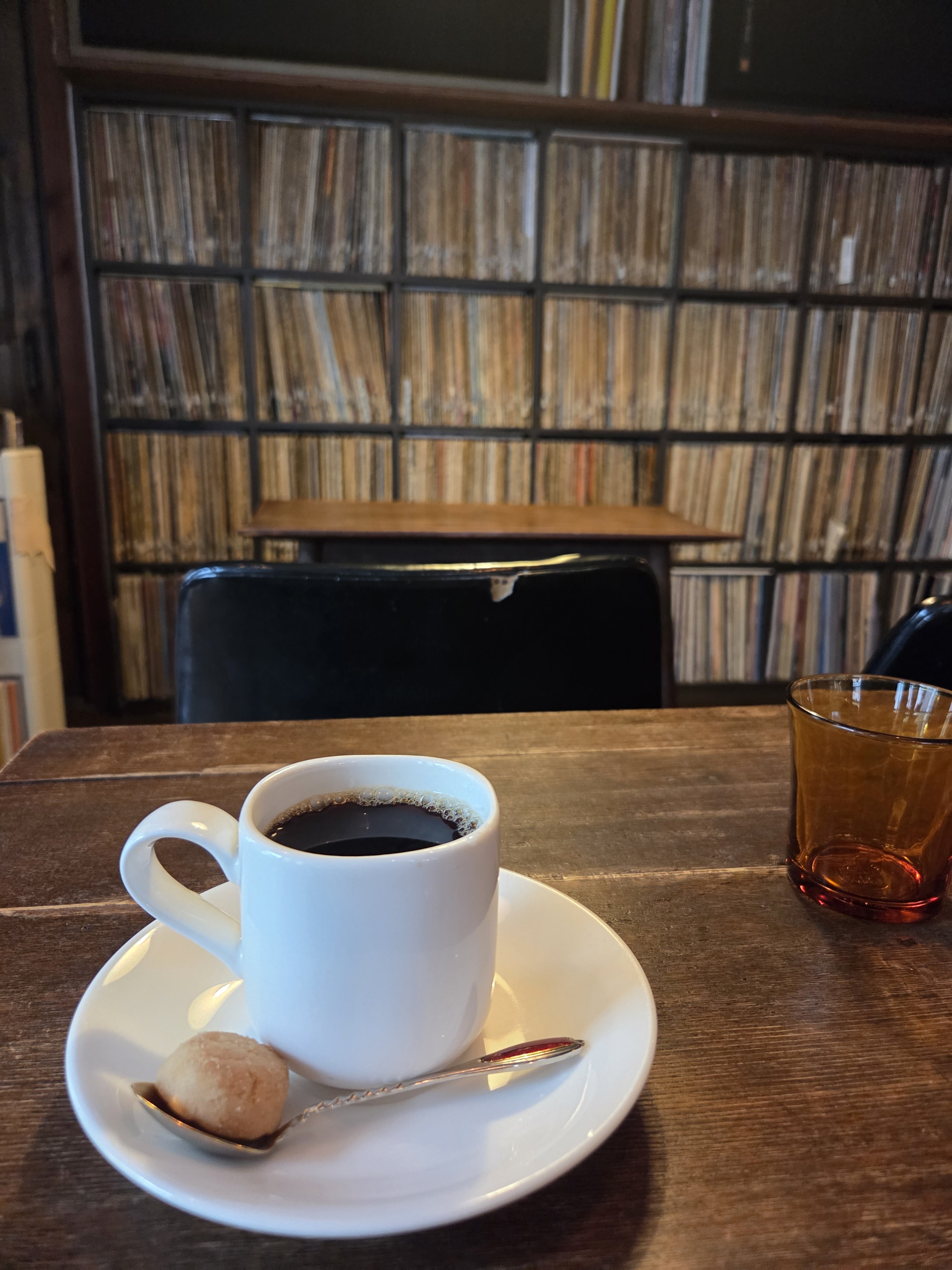 Coffee in front of a jazz kissaten's record collection